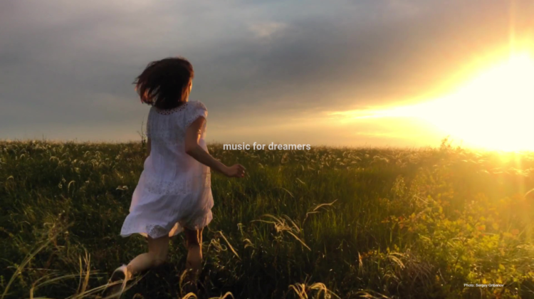 Woman running in a field. Music for dreamers.